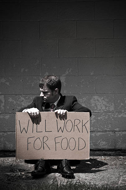 istock Unemployed Businessman Holding Will Work For Food Sign 471220013
