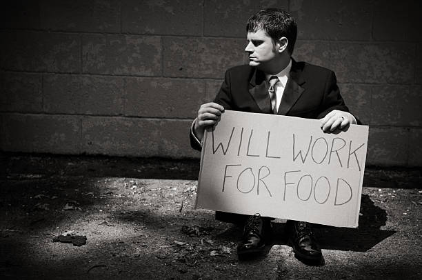 istock Unemployed Businessman Holding Will Work For Food Sign 471220015