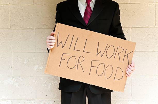 istock Unemployed Businessman Holding Will Work For Food Sign 471220019