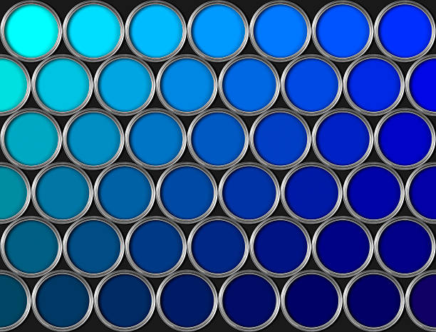 Tins of blue paint in rows on black background stock photo