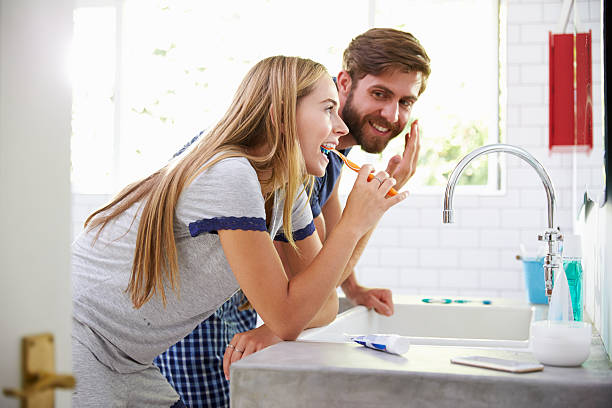 istock Couple In Pajamas Brushing Teeth And Putting On Moisturizer 471221234
