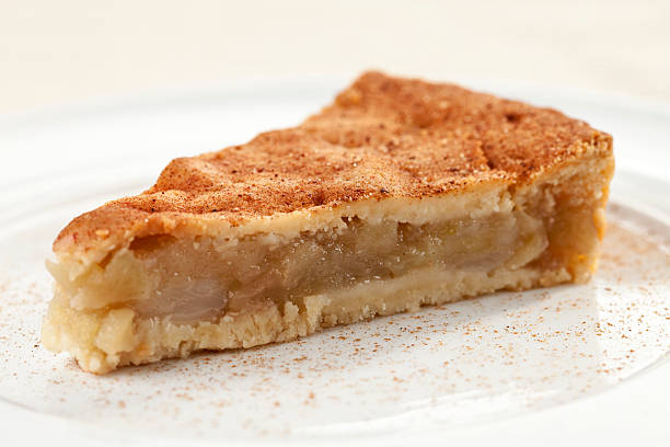 Walnut-apple pie slice with a fork on a white plate background. Copy space available.
