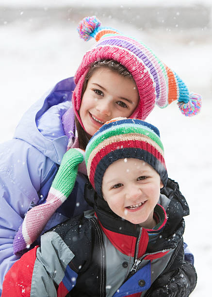 istock Two Children in the Snow with Knit Hats 471228865
