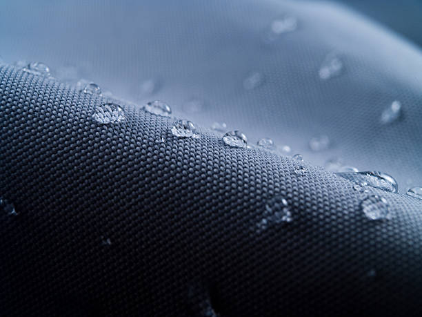 waterproof textile clothing blue Macro shot of water rain drops on waterproof textile jacket. Extreme depth of field. Please visit my portfolio for different shots of this subject. waterproof photos stock pictures, royalty-free photos & images