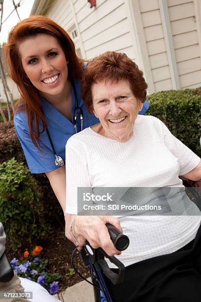 Trabajador De Asistencia Sanitaria Ayudando A Senior Feliz Adultos En Walkerrider Foto de stock y más banco de imágenes de 70-79 años