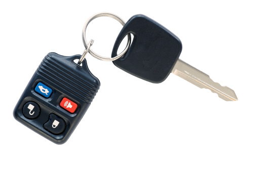  A car key and remote door locking device on a simple keyring, isolated on white.