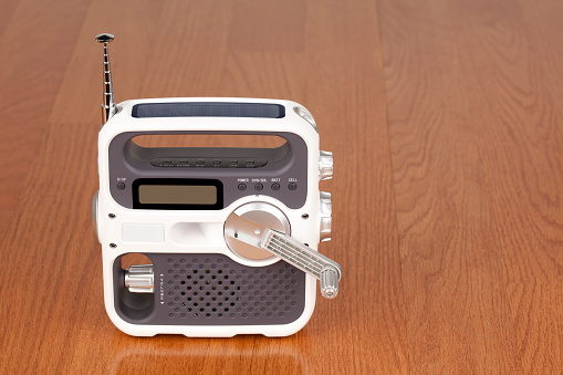 Portable emergency radio with solar cell and hand crank for power.