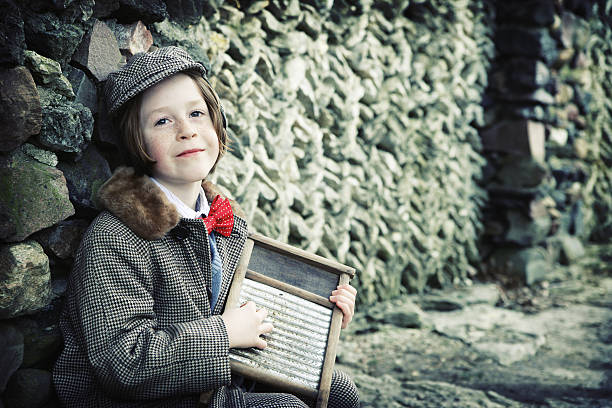 Adorable Little Musician with Suit, Bow Tie and Washboard Adorable little boy in vintage hat and jacket and red bow tie plays washboard by stone wall. rockabilly boys stock pictures, royalty-free photos & images