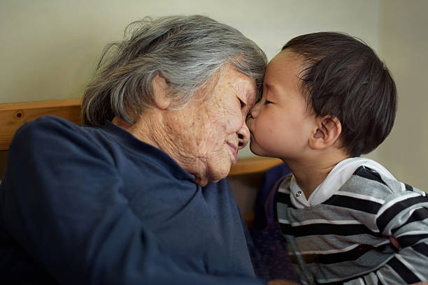 Asian little boy kissing grandmother Asian little boy kissing grandmother korean baby stock pictures, royalty-free photos & images