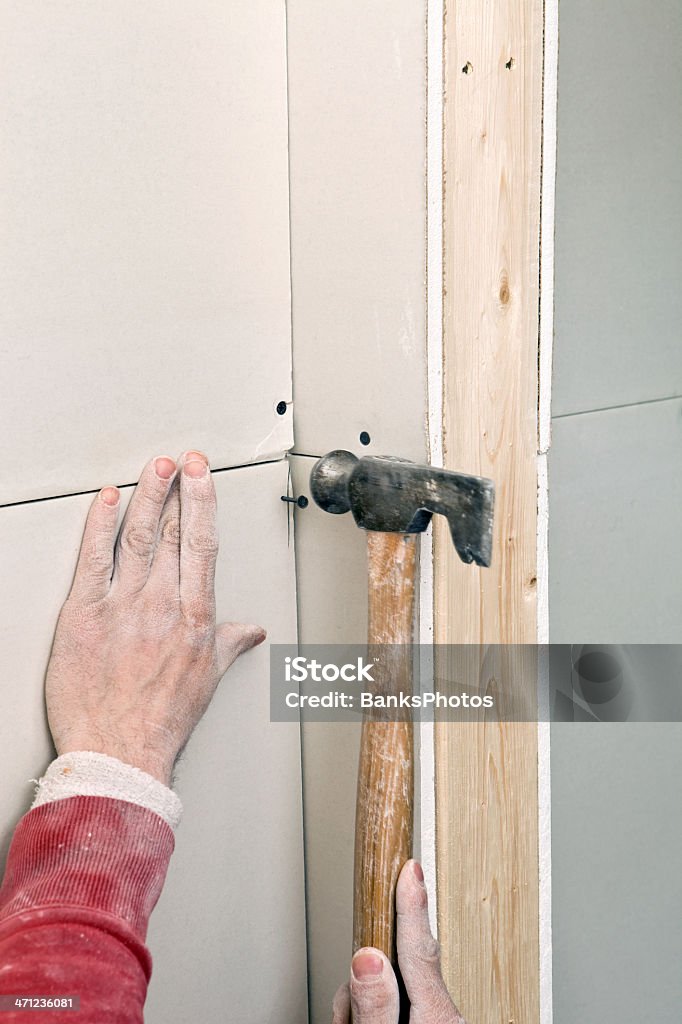 Trabajador de la construcción de bastidor de fijación Sheetrock pared - Foto de stock de Bricolaje libre de derechos