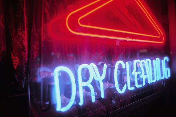 A neon dry-cleaning sign lit during the night.