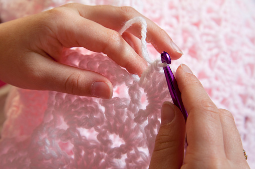 Close up of hands crocheting a pink baby blanket. Copyspace.You might also be interested in these: