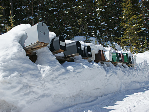 Winter scene.  A row of rural mail boxes are covered in deep winter snow in Colorado.