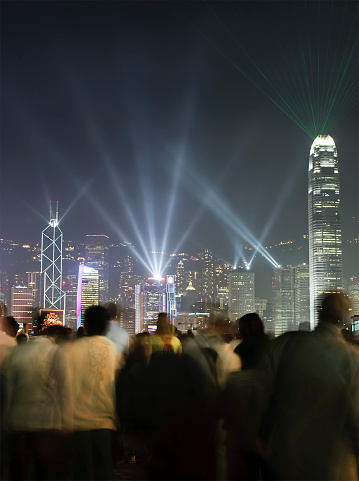 A crowd watch the weekly light show featuring famous buildings on Hong Kong island.