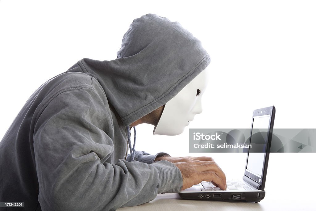 Homem com uma máscara e capuz usando computador, Internet, conceito de segurança - Foto de stock de Hacker royalty-free