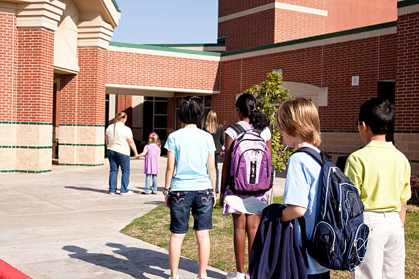 istock Students waiting outside for school to begin. Elementary education. Children. 471243533