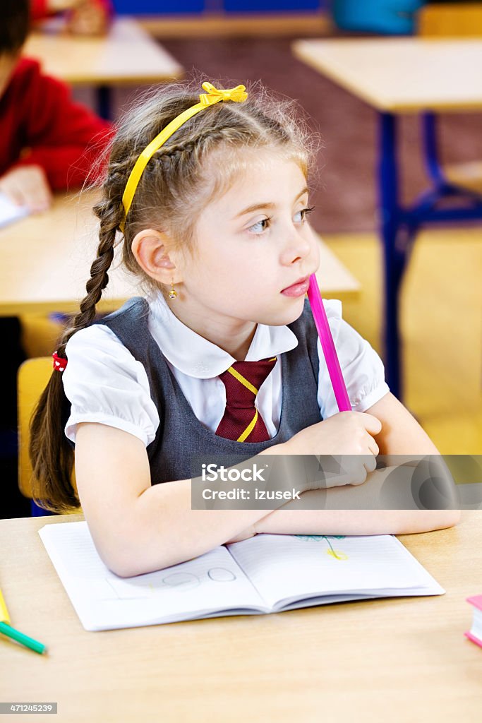 Pensive School Girl Daydreaming Close up of a school girl daydreaming in a classroom. 6-7 Years Stock Photo
