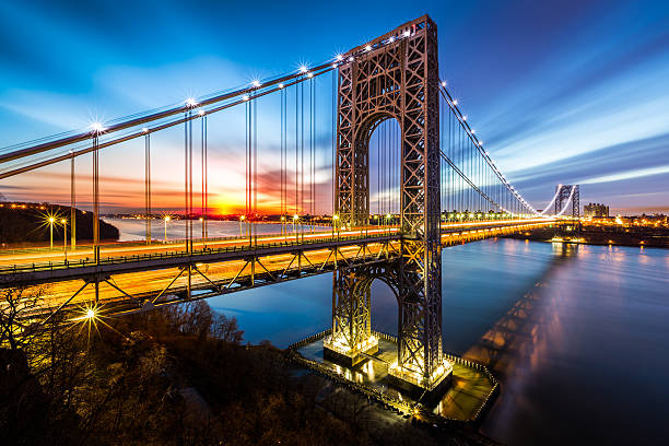 George Washington Bridge lit up at sunrise George Washington Bridge at sunrise in Fort Lee, NJ. George Washington Bridge is a suspension bridge spanning the Hudson River, connecting NJ to Manhattan, NY. gwb stock pictures, royalty-free photos & images