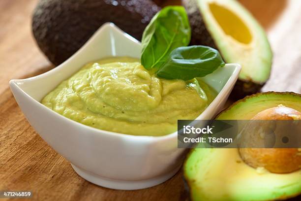 A Bowl Of Green Guacamole With Leaves On Side Stock Photo - Download Image Now - Avocado, Close-up, Cross Section