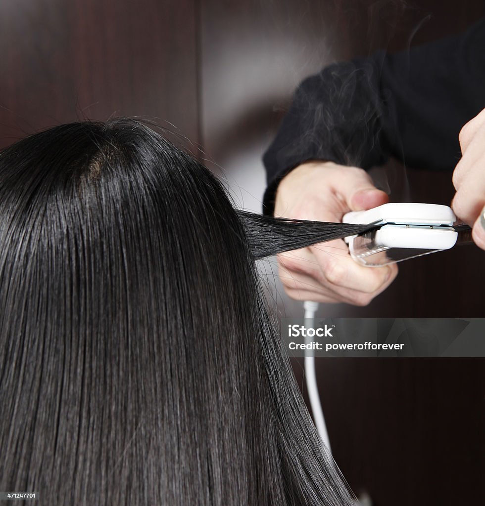 Parrucchieri Straitening una sezione di capelli - Foto stock royalty-free di Ferro stiracapelli
