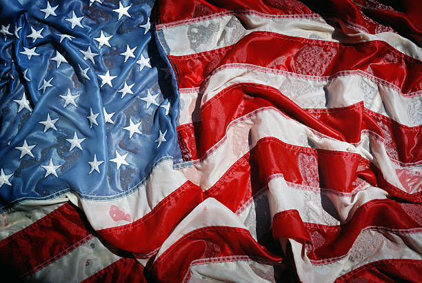 istock Sun Reflects on Soaking Wet Crumpled and Faded American Flag 471248313