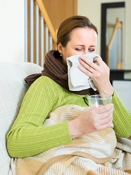 istock Ill woman blowing nose 471250622