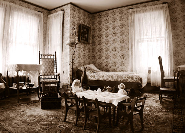 Antique bedroom interior with a wooden bed, a chair holding a cane, top hat, and white shirt, and a chamber pot placed beside the bed