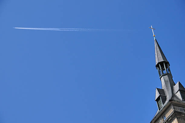 istock Church steeple, golden cross, jet stream against deep blue sky 471252613