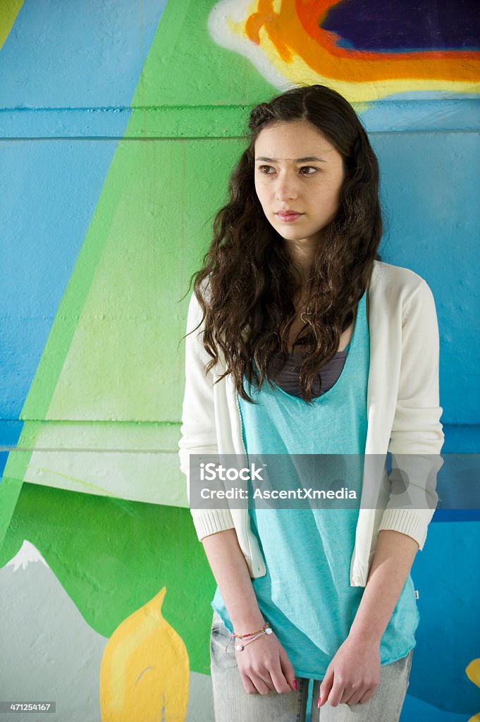 Urban portrait Portrait of a beautiful young woman against a graffiti covered wall Serious Stock Photo