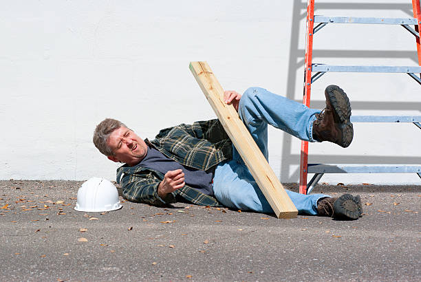 Injured construction worker fallen off ladder stock photo