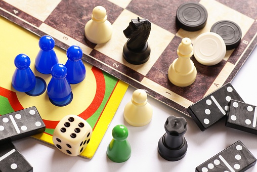 Chess board with golden pieces on wooden table against blurred background, space for text