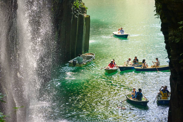 Takachiho, Japan - September 28, 2014: tourists visting the Takachiho Gorge and the Manai Waterfall using small boats.