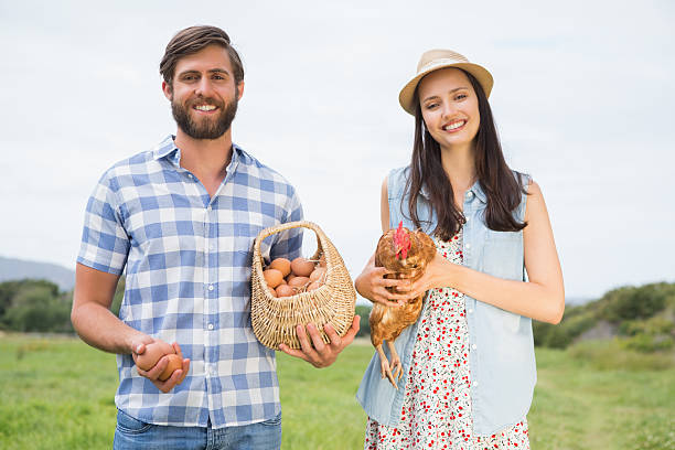 istock Happy farmers holding chicken and eggs 471255244