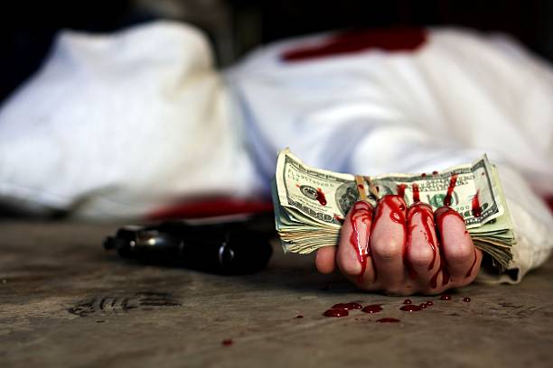 Blood Money A murder victim clutching a stack of $100 bills in his bloody hand, with a .45 caliber 1911 handgun laying nearby. bloody money stock pictures, royalty-free photos & images