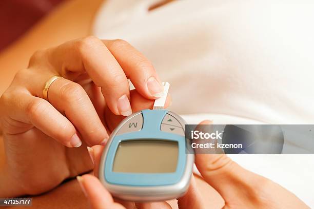 Woman Holding Glucose Meter And Testing Blood For Diabetes Stock Photo - Download Image Now