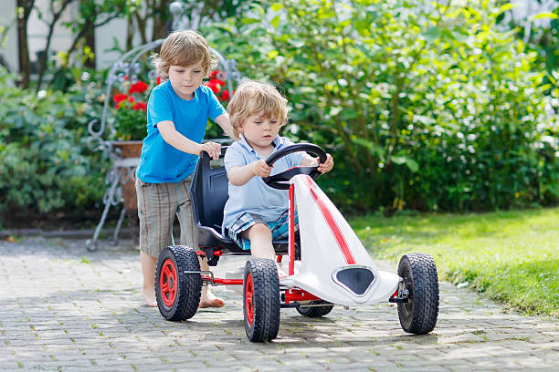 istock Two happy kid boys having fun with toy car 471258660