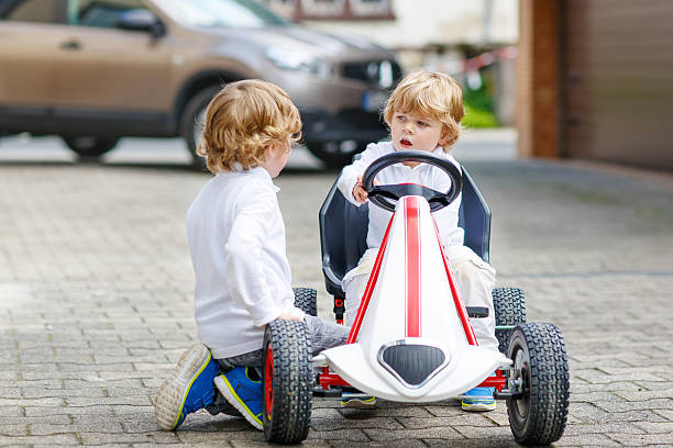 istock Two happy sibling boys playing with toy car 471258704