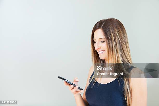 Woman Checking Notifications On Smart Phone Stock Photo - Download Image Now - 20-29 Years, 2015, 30-39 Years
