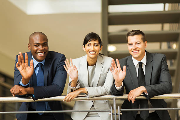 istock businesspeople waving in office 471259762