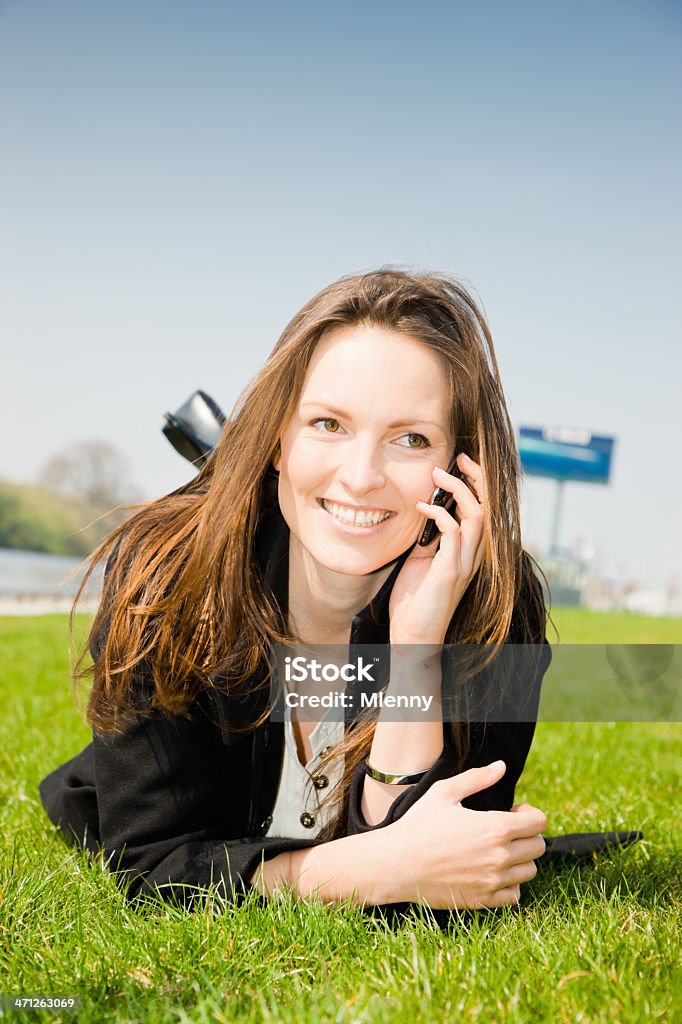 Счастливый мобильному телефону Молодая женщина, лежа на траве - Стоковые фото 20-29 лет роялти-фри