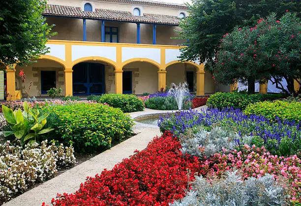 A section of the colorful gardens of Espace Van Gogh in Arles, France.  Formerly the Hôtel-Dieu hospital where Dutch artist Van Gogh was interred, the buildings are now a cultural centre. The courtyard has been planted to resemble the famous painting "Le Jardin de l'Hôtel de Dieu". 