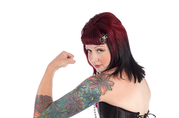 istock Tattooed pinup girl flexes bicept. 471264417