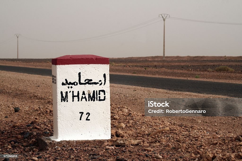 Desert road milestone Milestone along the "Erg Chigaga" desert road, leading to the village of M'hamid. Arabic Script Stock Photo