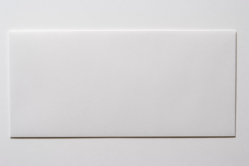 Close-up shot of blank white envelope isolated on white background.