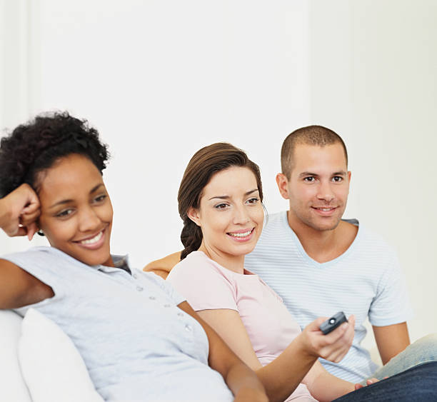 istock Young man and women sitting together while watching television 471265871