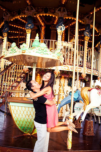 Mother and her baby boy enjoying a vintage carousel ride at an amusement park, bonding and creating cherished childhood memories in a festive and joyful moment