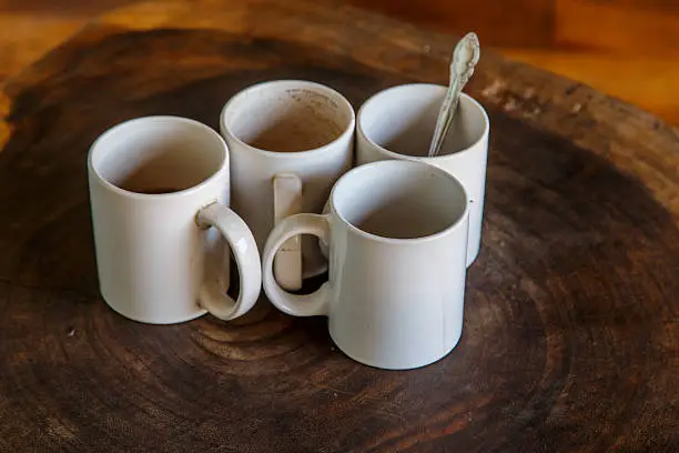 Photo of four coffee cups in wooden table