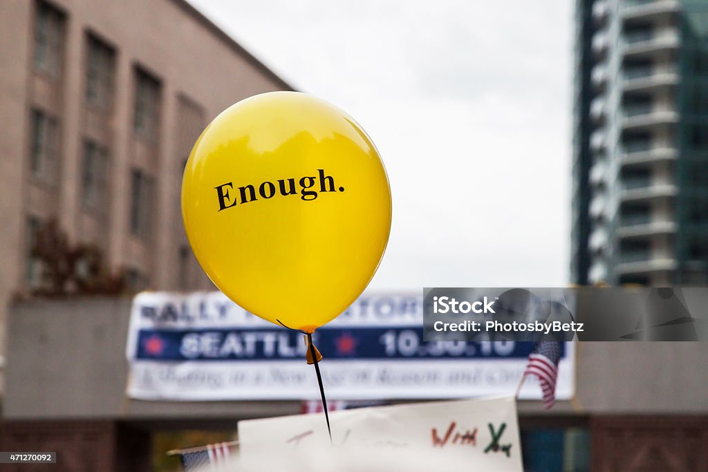 "Enough" political rally Yellow balloon stating "Enough" at a political rally. Protest Stock Photo