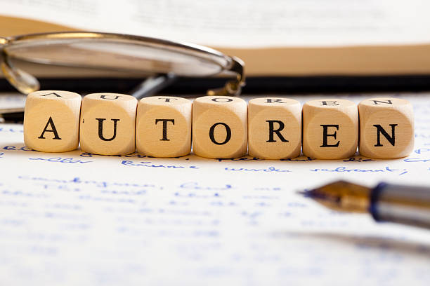 Letter Dices Concept: Autoren (German) Concept of dices with letters forming words: Autoren (German version of "authors"). Generic handwritten text, pen, glasses and books as background. autoren stock pictures, royalty-free photos & images