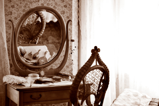 Vintage Lowboy with Vanity Mirror in Bedroom. Vintage cosmetics and hair brushes lying on top. - high ISO settings